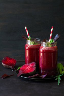 Taze pancar güler yüzlü, pancar, roka ve marul yaprakları koyu ahşap arka plan üzerinde