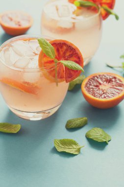 Kan portakal dilimleri turkuaz arka plan üzerinde Orange ile kokteyl. Tonda