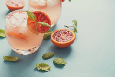 Kan portakal dilimleri turkuaz arka plan üzerinde Orange ile kokteyl. Tonda
