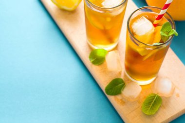 Limon dilimleri ve turkuaz ahşap zemin üzerine nane ile buzlu çay bardak