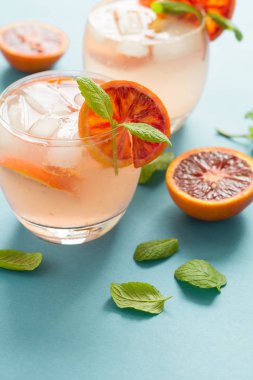 Kan portakal dilimleri turkuaz arka plan üzerinde Orange ile kokteyl