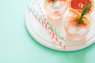 Ferahlık greyfurt Beyaz ahşap tahta üzerinde rosemary ile kokteyl. Sağlıklı narenciye yaz içeceği. Nane renk arka plan