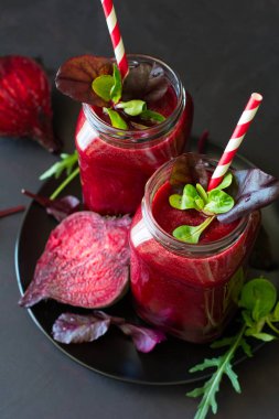 Taze pancar güler yüzlü, pancar, roka ve marul yaprakları koyu ahşap arka plan üzerinde