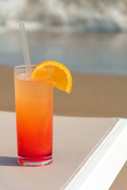 Arka plan mavi su ile sahilde renkli kokteyller ile gözlük