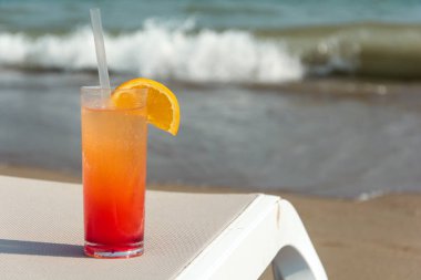 Arka plan mavi su ile sahilde renkli kokteyller ile gözlük