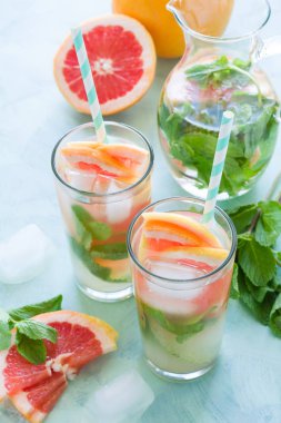 Ferahlık greyfurt nane nane kokteyli arka planını renklendirin. Sağlıklı narenciye yaz içeceği.