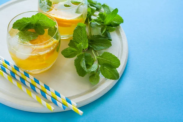 Pomarańczowy Lemoniady Plastrami Pomarańczy Lodu Mięta Niebieskim Tle — Zdjęcie stockowe