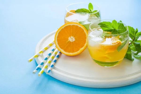 Pomarańczowy Lemoniady Plastrami Pomarańczy Lodu Mięta Niebieskim Tle — Zdjęcie stockowe
