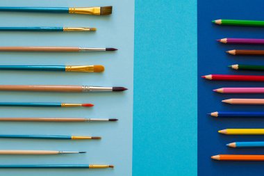 Çok renkli kalemler ve fırçalar mavi kağıt üzerinde. Okula dönüş. Uzay kopyalayın. Üstten Görünüm. Düz yatıyordu