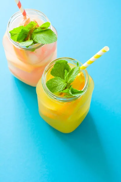 Słoiki Pomarańczowy Grejpfrutowy Lemoniady Urządzone Lodu Mięta Tle Niebieski Papier — Zdjęcie stockowe