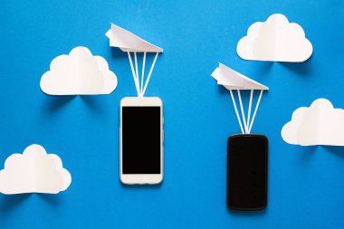 Veri aktarım kavramı. İleti gönderme. İki hareket eden smartphones ve mavi arka plan üzerinde kağıt airpaplanes. Origami. Kağıt kesiği.