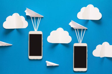 Veri aktarım kavramı. İleti gönderme. İki hareket eden smartphones ve mavi arka plan üzerinde kağıt airpaplanes. Origami. Kağıt kesiği.