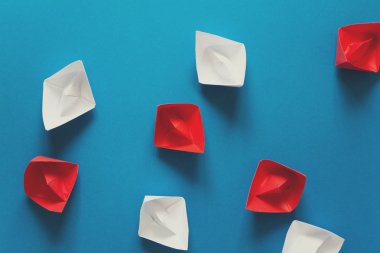 Mavi kağıt arka plan üzerinde kırmızı ve beyaz origami deniz araçları kümesi. Yaz seyahat kavramı. Üstten Görünüm. Tonda