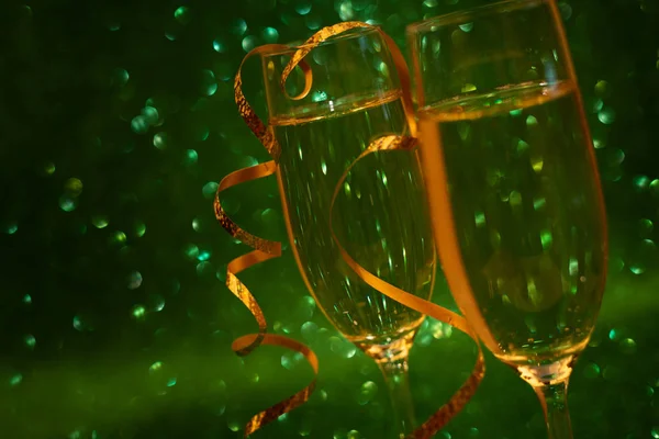 Дві Склянки Шампанського Прикрашали Золоті Стрічки Зеленому Блискучому Тлі Різдвяні — стокове фото