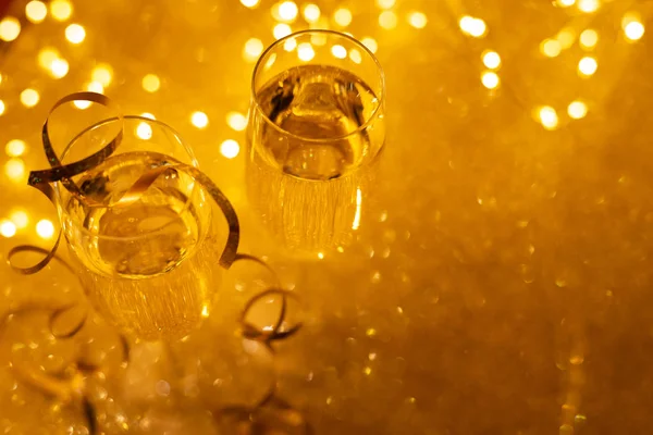 Top View Two Glasses Champagne Golden Glittering Background Defocused Lights — Stock Photo, Image