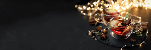 Banner 3: 1. Dos tazas de vino caliente navideño con especias y rodajas de limón sobre fondo de madera oscura con luces desenfocadas. Concepto de celebración de Navidad o Año Nuevo — Foto de Stock