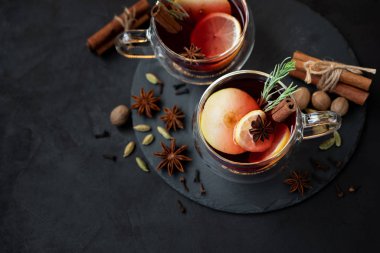İki bardak Noel şarabı ya da koyu ahşap arka planda baharat ve limon dilimli gluhwein. Noel veya Yeni Yıl Kutlama Konsepti