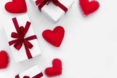 Beyaz arka planda keçeli kalple sarılmış kırmızı kurdeleli hediye kutularının sınırı. Sevgililer Günü ya da Kadınlar Günü konsepti. Üst görünüm.