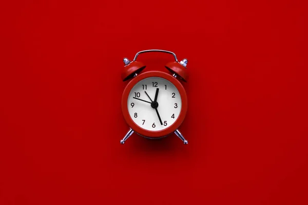 Reloj despertador sobre fondo rojo. Vista superior. Puesta plana — Foto de Stock