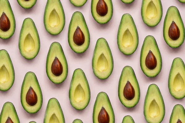 Yaz yemekleri. Avokado yarım pembe arka planda. Üst Manzara. Düz yatıyordu