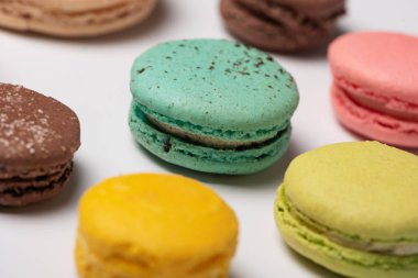 Beyaz arka planda renkli Fransız badem kurabiyelerinin yakın çekim deseni. Düz yatıyordu. Seçici odak