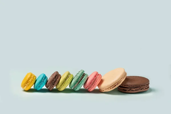 French macaroons on turquoise background. Flat lay. Front view. Selective focus