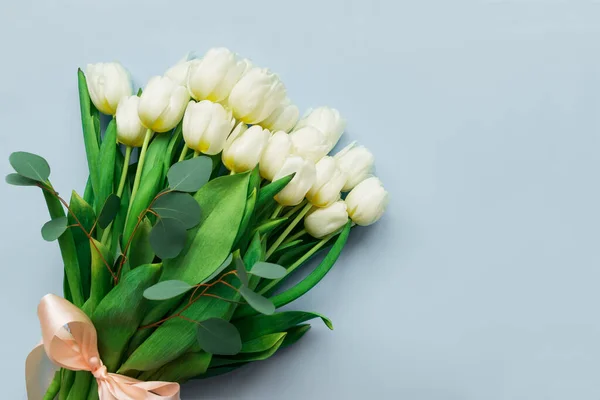 Gri arka planda bir buket beyaz lale. Sevgililer günü, anneler günü, 8 Mart veya doğum günü kutlaması konsepti