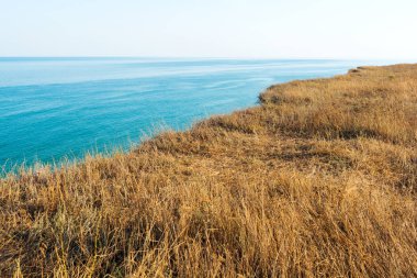 Bozkırdaki kuru çimenli deniz kıyısında. Dağdan deniz manzarası. Seyahat kavramı