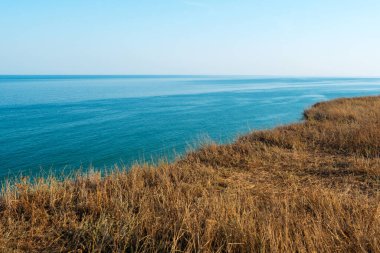 Bozkırdaki kuru çimenli deniz kıyısında. Dağdan deniz manzarası. Seyahat kavramı