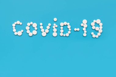 Covid-19 karantinası. Mavi arka plandaki beyaz haplardan yapılmış. Grip, hastalık, pandemik konsept