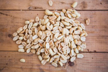 Ahşap arka planda yer fıstığı var. Ahşap masada Arahis..