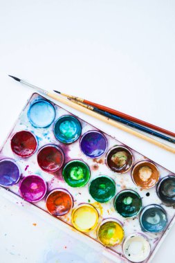 Beyaz arkaplanda çok renkli suluboya boya setleri