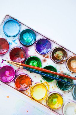 Beyaz arkaplanda çok renkli suluboya boya setleri