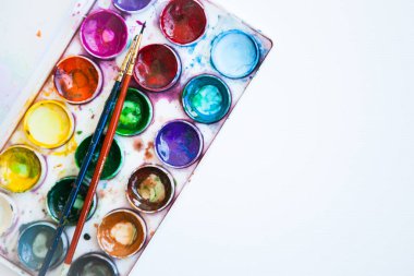 Beyaz arkaplanda çok renkli suluboya boya setleri