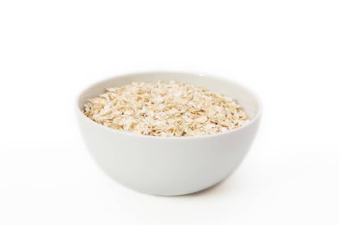 Beyaz bir arka plan üzerinde beyaz bir kase yulaf gevreği