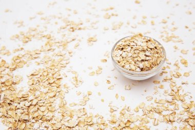 Beyaz bir arka plan üzerinde küçük bir şeffaf kase yulaf gevreği