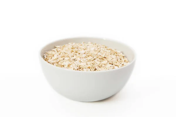 Beyaz bir arka plan üzerinde beyaz bir kase yulaf gevreği