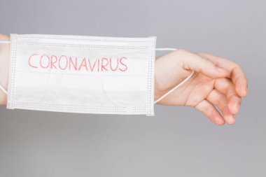 Roman Coronavirus - CORONAVIRUS yazılı cerrahi maske koruyucu maske. Çin Coronavirüs salgını. Maskeli kadın.