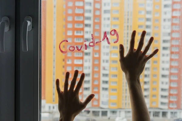 hands on the window with text covid-19