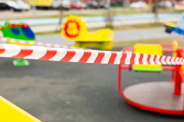 Çocuk parkında baraj bandı. Kırmızı-beyaz şeritli kurdele. Dur çizgisi