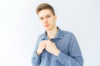 Açık gri arka planda mavi gömlekli genç bir adam. İşçi ve girişimci