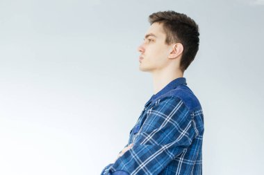 Açık gri arka planda mavi gömlekli genç bir adam. İşçi ve girişimci