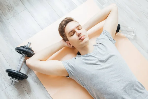 Genç adam spor için eve gider. Evde spor faaliyetleri