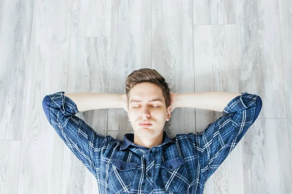 Νεαρός Μπλε Πουκάμισο Ξαπλωμένος Γκρι Ξύλινο Πάτωμα Χαλαρωτικός Άνθρωπος — Φωτογραφία Αρχείου