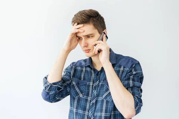Ένας Νεαρός Μιλάει Στο Τηλέφωνο Ανοιχτό Γκρι Φόντο Άνθρωπος Σκέφτηκε — Φωτογραφία Αρχείου