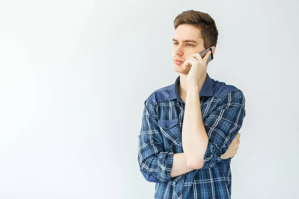 Ένας Νεαρός Μιλάει Στο Τηλέφωνο Ανοιχτό Γκρι Φόντο Άνθρωπος Σκέφτηκε — Φωτογραφία Αρχείου