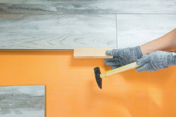 man puts a new laminate flooring. Repair in the apartment. Worker repairs the floor. Laminate Laying Process