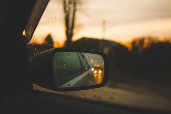 Arka planda damlalar olan araba aynası. Bir yolculukta yol