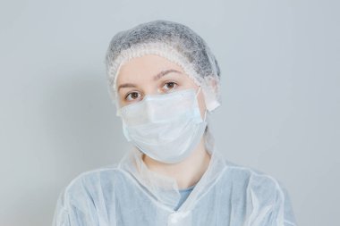 Tıbbi maskeli ve koruyucu giysili bir doktor.
