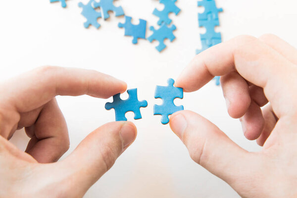 Blue puzzle in hand. Hand holding puzzle piece on white background. Connecting piece jigsaw puzzle, Business connection, education, society and teamwork